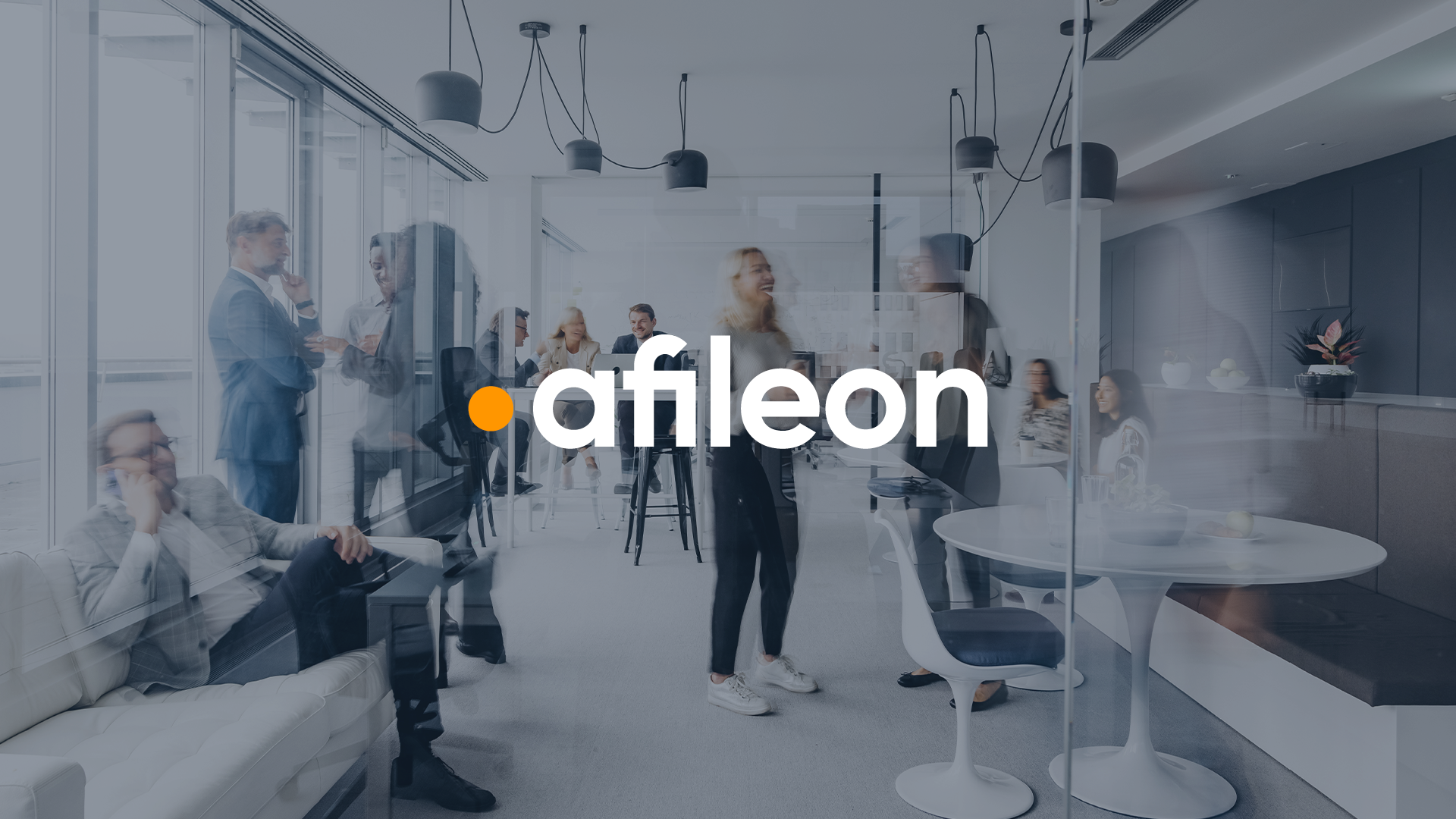 Ein modernes Bürointerieur mit mehreren Personen, die miteinander kommunizieren und arbeiten. In der Mitte des Bildes steht das Logo „afileon“ deutlich sichtbar.